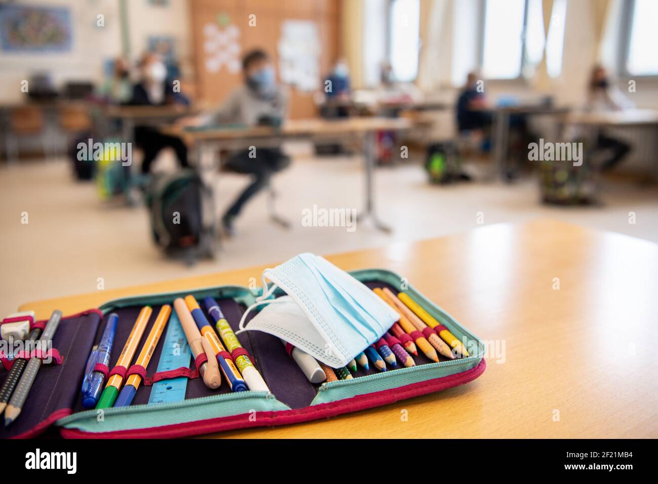München, Deutschland. März 2021, 10th. Der Ersatz-Mundschutz eines Schülers liegt auf dem Bleistiftkasten des Schülers während des Unterrichts in einer vierten Klasse an einer Grundschule. Der bayerische Bildungsminister Piazolo (Freie Wähler) und der bayerische Gesundheitsminister Holetschek (CSU) besuchten die Grundschule, um die Umsetzung der Corona-Teststrategie zu sehen. Quelle: Matthias Balk/dpa/Alamy Live News Stockfoto