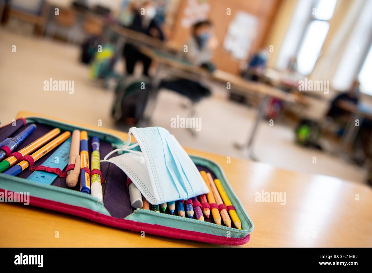 München, Deutschland. März 2021, 10th. Der Ersatz-Mundschutz eines Schülers liegt auf dem Bleistiftkasten des Schülers während des Unterrichts in einer vierten Klasse an einer Grundschule. Der bayerische Bildungsminister Piazolo (Freie Wähler) und der bayerische Gesundheitsminister Holetschek (CSU) besuchten die Grundschule, um die Umsetzung der Corona-Teststrategie zu sehen. Quelle: Matthias Balk/dpa/Alamy Live News Stockfoto