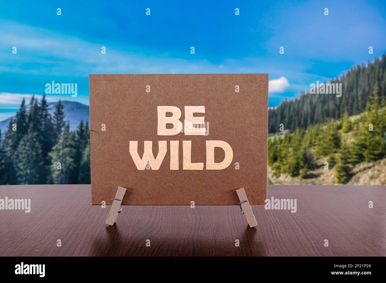 Sei wild Text auf Karte auf dem Tisch mit Bergtal Hintergrund. Stockfoto