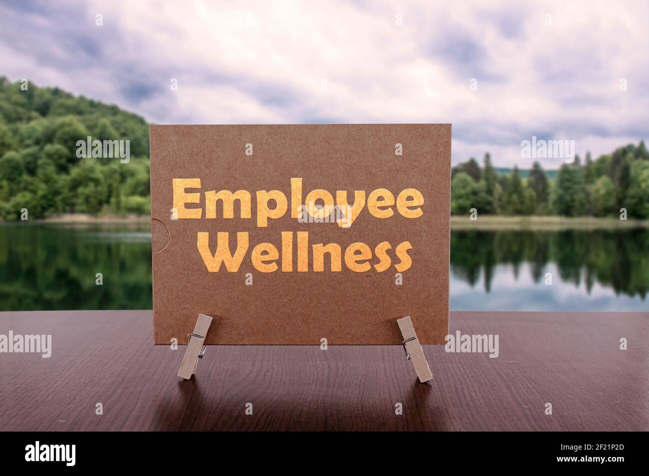 Mitarbeiter Wellness Text auf Karte auf dem Tisch mit ruhigen See Hintergrund. Stockfoto