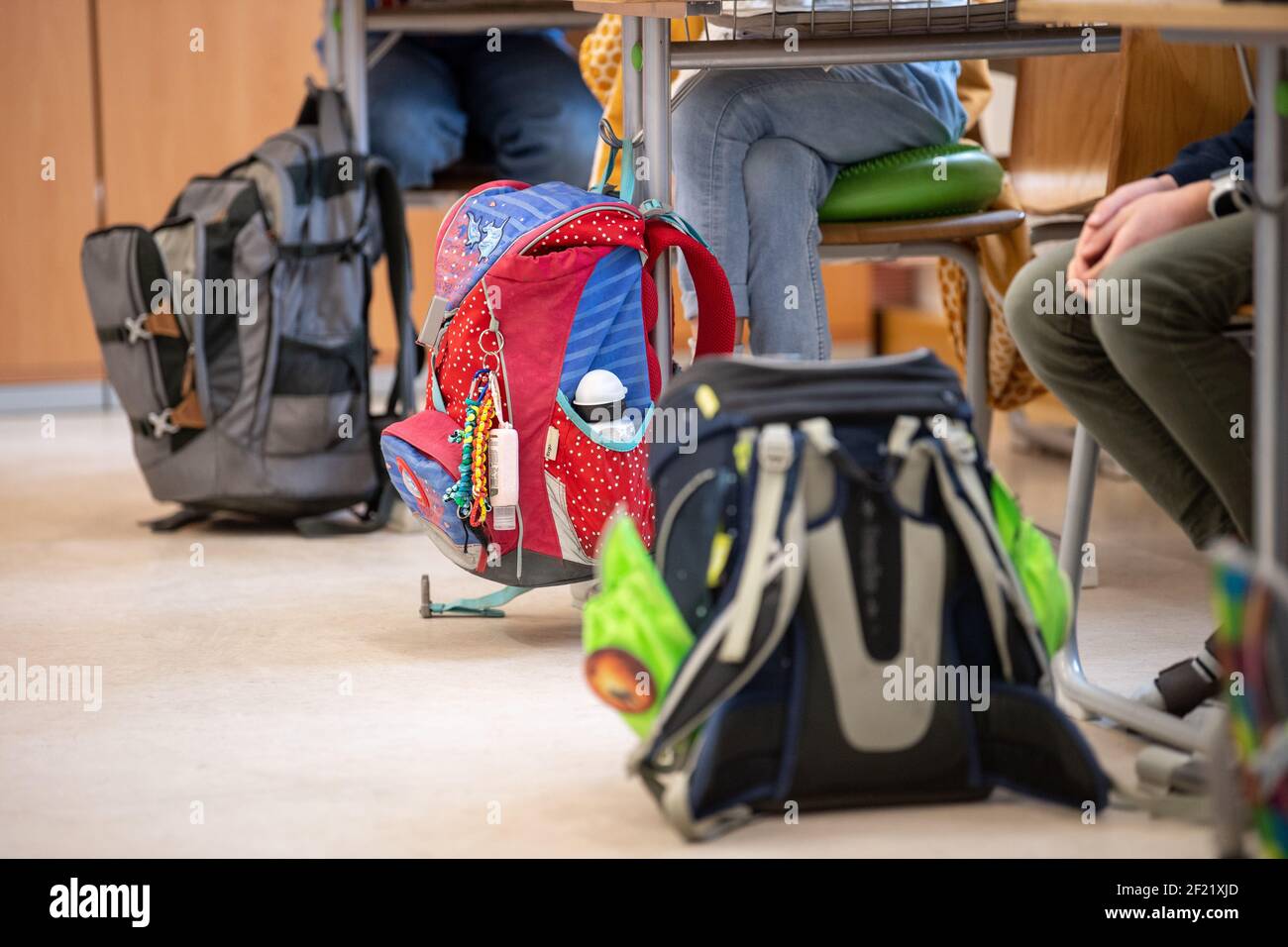 München, Deutschland. März 2021, 10th. Die Schultaschen der Schüler einer vierten Klasse einer Grundschule sind neben den Kindertischen während des Unterrichts zu sehen. Der bayerische Bildungsminister Piazolo (Freie Wähler) und der bayerische Gesundheitsminister Holetschek (CSU) besuchen die Grundschule, um sich über die Umsetzung der Corona-Teststrategie zu überzeugen. Quelle: Matthias Balk/dpa/Alamy Live News Stockfoto