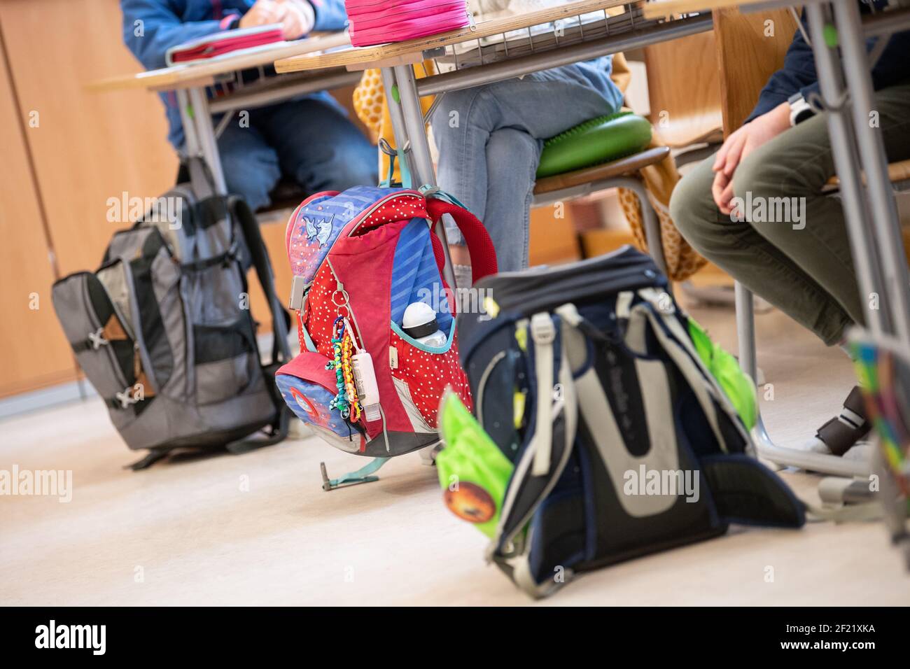 München, Deutschland. März 2021, 10th. Die Schultaschen der Schüler einer vierten Klasse einer Grundschule sind neben den Kindertischen während des Unterrichts zu sehen. Der bayerische Bildungsminister Piazolo (Freie Wähler) und der bayerische Gesundheitsminister Holetschek (CSU) besuchen die Grundschule, um sich über die Umsetzung der Corona-Teststrategie zu überzeugen. Quelle: Matthias Balk/dpa/Alamy Live News Stockfoto