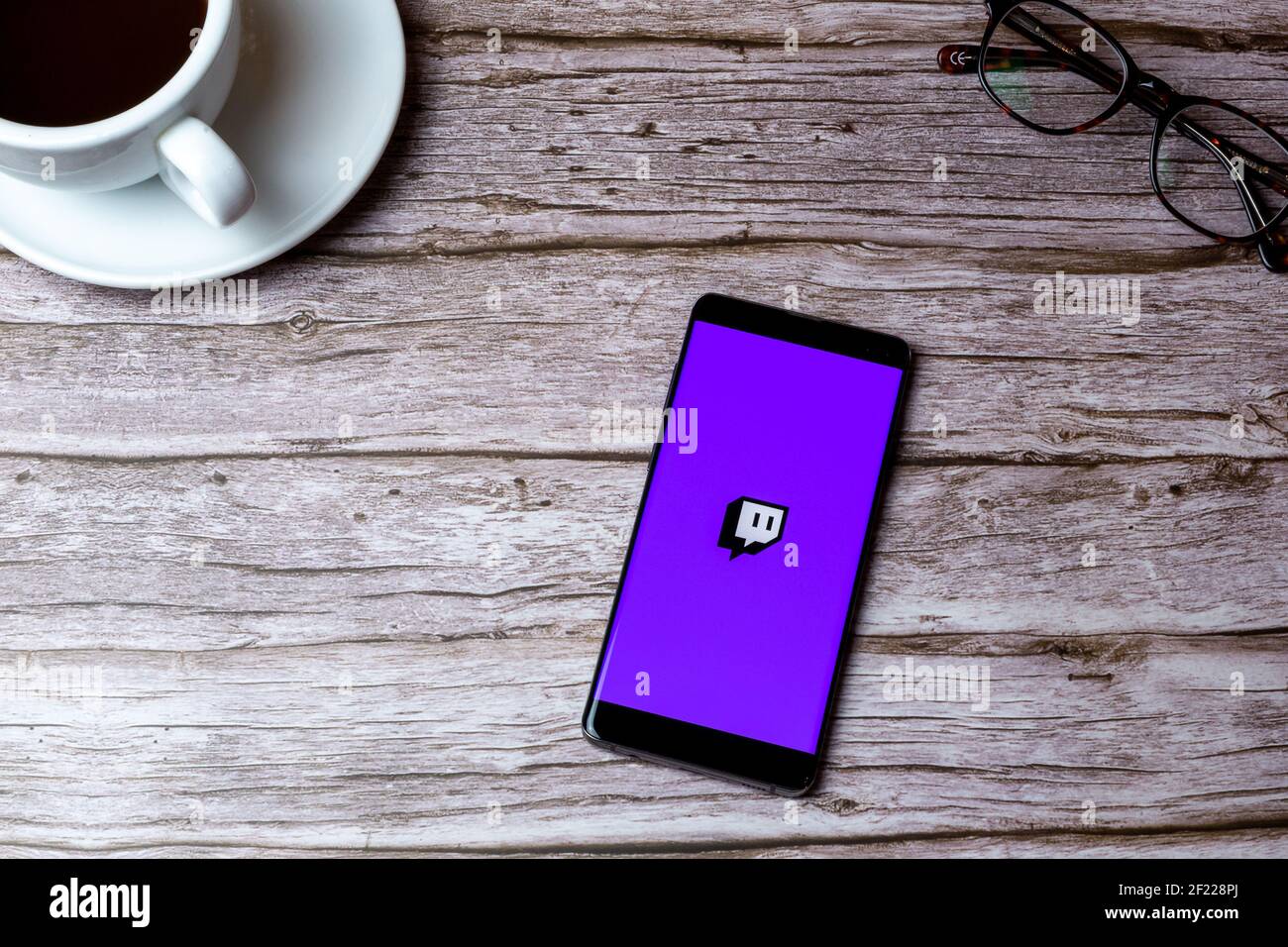 Ein Handy oder Handy auf einem Holz gelegt Tisch oder Schreibtisch mit der Twitch Streaming-App geöffnet Stockfoto