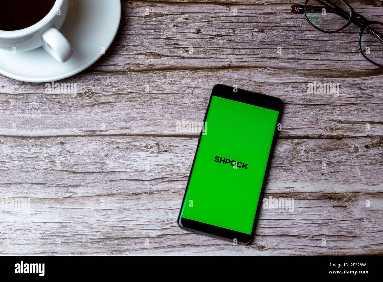 Ein Handy oder Handy auf einem Holz gelegt Tisch oder Schreibtisch mit der Shpock App geöffnet Stockfoto