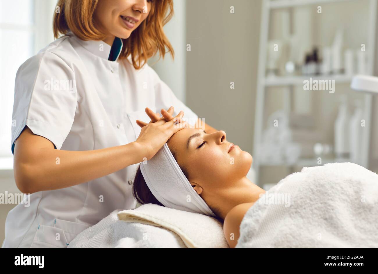 Kosmetikerin oder Dermatologin, die Gesichtsmassagen für junge Menschen macht Frau in Beauty-Spa-Salon mit Fingern Stockfoto