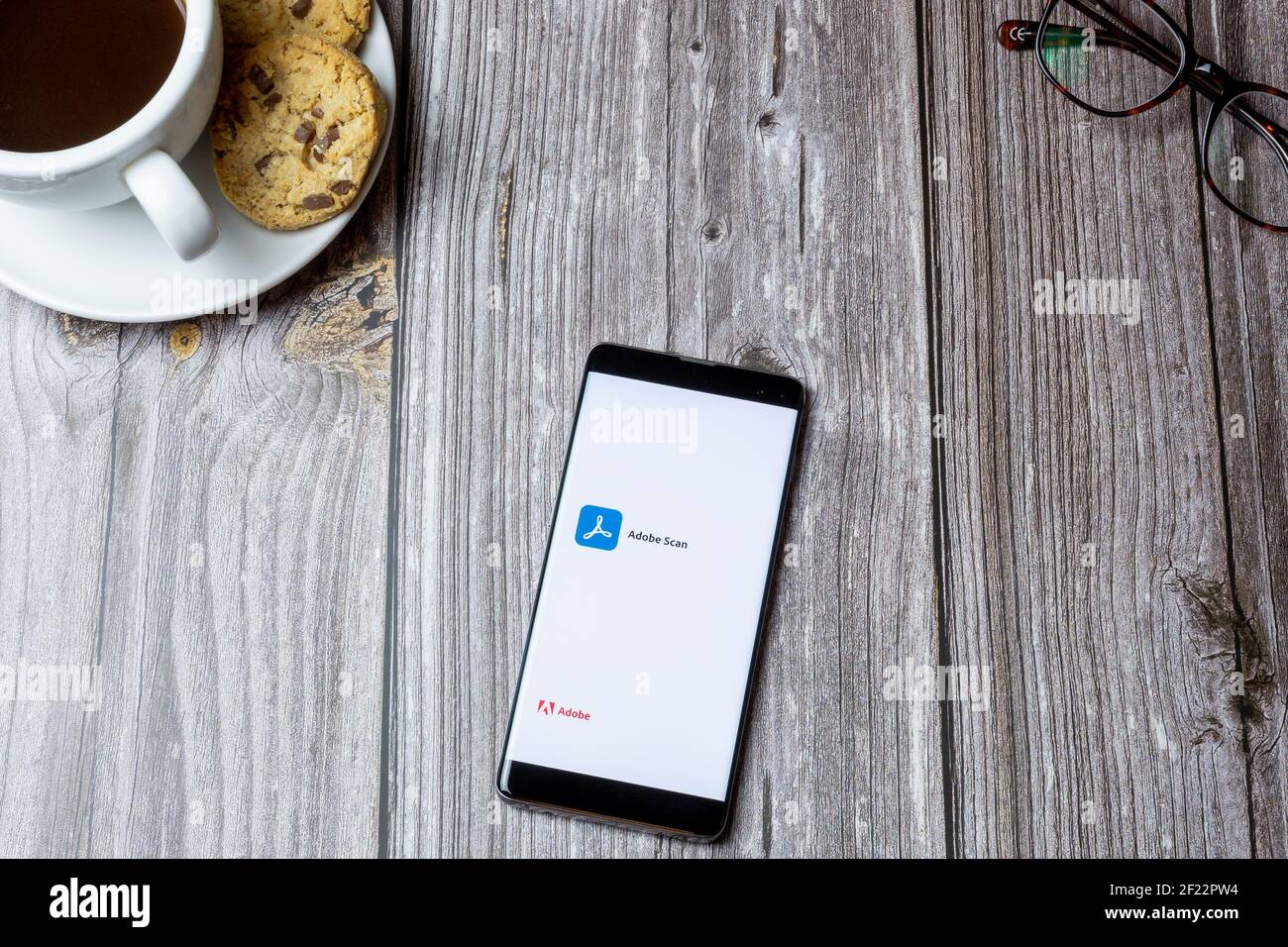 Ein Handy oder Handy auf einem Holz gelegt Tabelle mit der geöffneten Adobe Scan-App auf dem Bildschirm Stockfoto