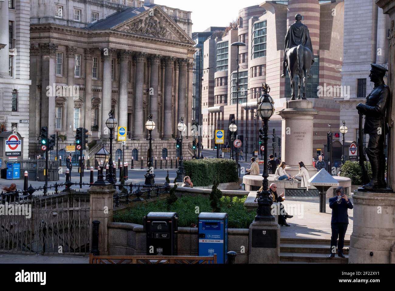 Reflektiertes Sonnenlicht beleuchtet die Bank Triangle Kreuzung während einer viel ruhigeren abendlichen Rush-Hour während der dritten Sperre der Coronavirus Pandemie. Finanzinstitute, die Statue des Duke of Wellington, das Mansion House und die Bank of England befinden sich hier, im Herzen der City of London, aka Square Mile, am 9th. März 2021, in London, England. Stockfoto