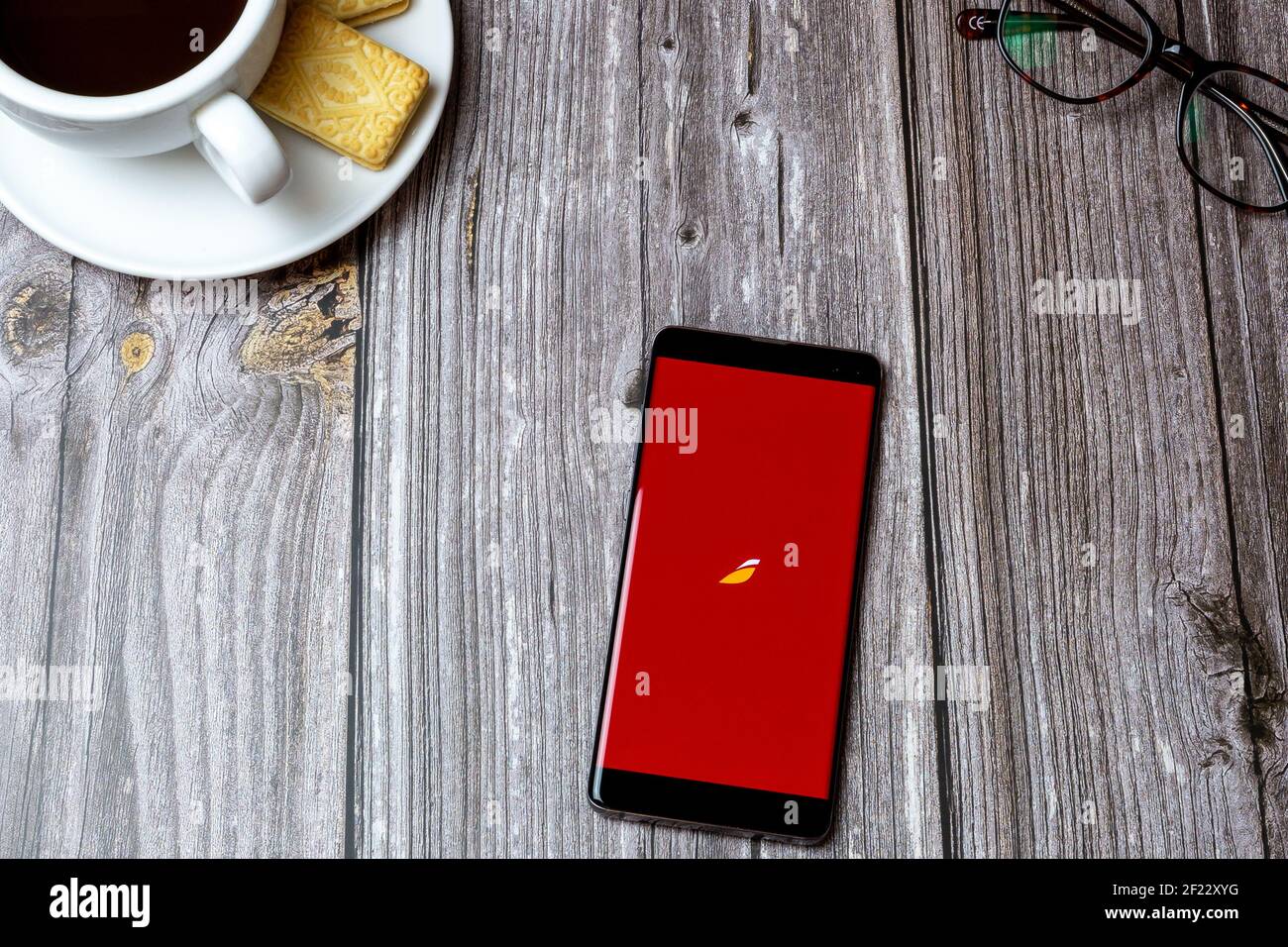 Ein Handy oder Handy auf einem Holztisch Mit der Iberia App geöffnet neben einem Kaffee und Brille Stockfoto