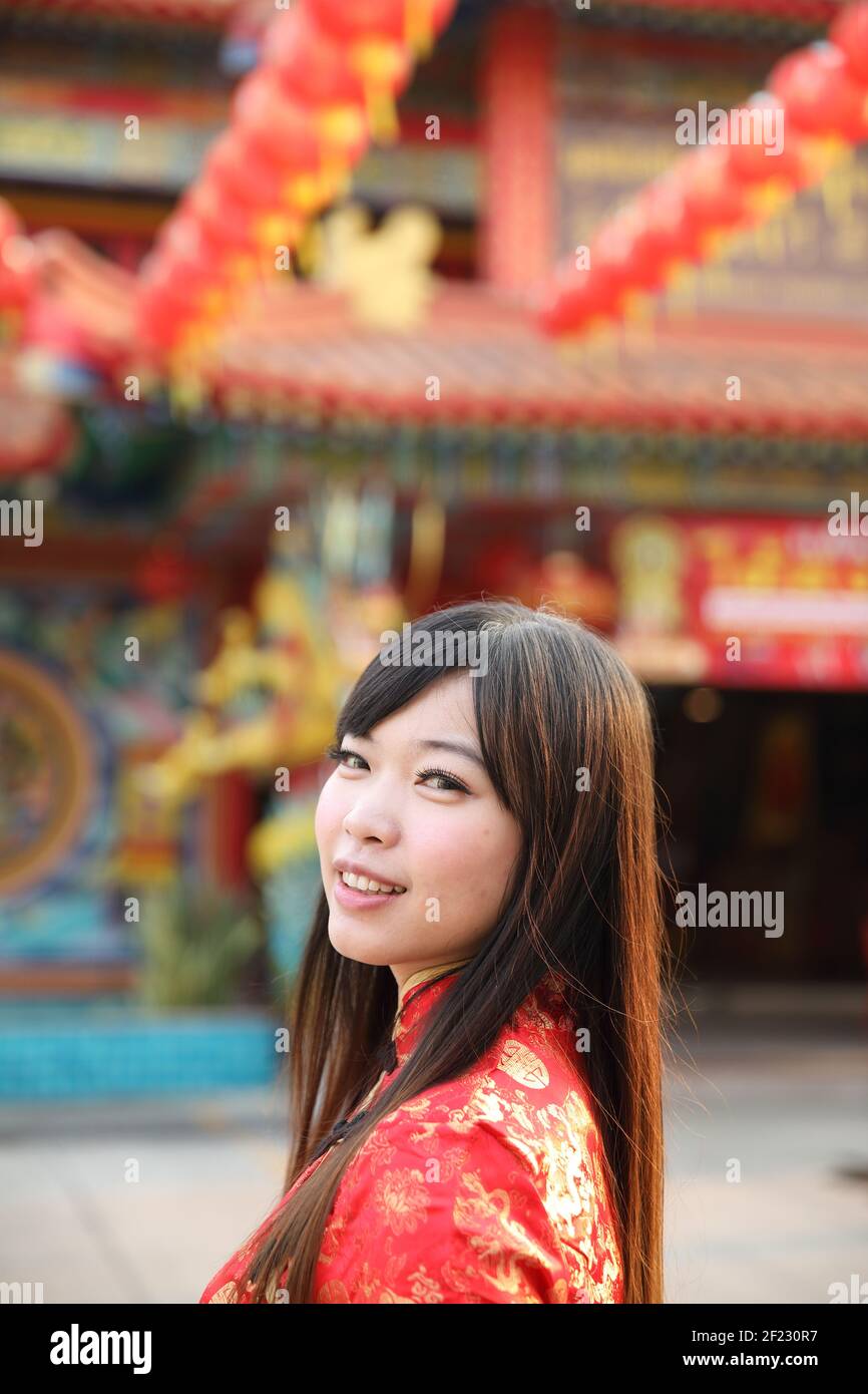 Schönheit Frau tragen rote cheongsam suchen und lächeln auf chinesisch Neues Jahr Stockfoto