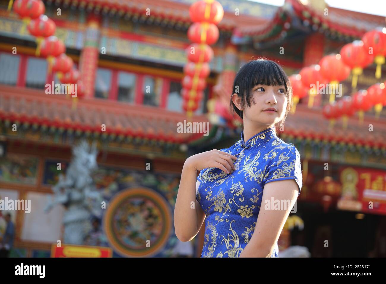 Schönheit Frau tragen rote cheongsam suchen und lächeln auf chinesisch Neues Jahr Stockfoto