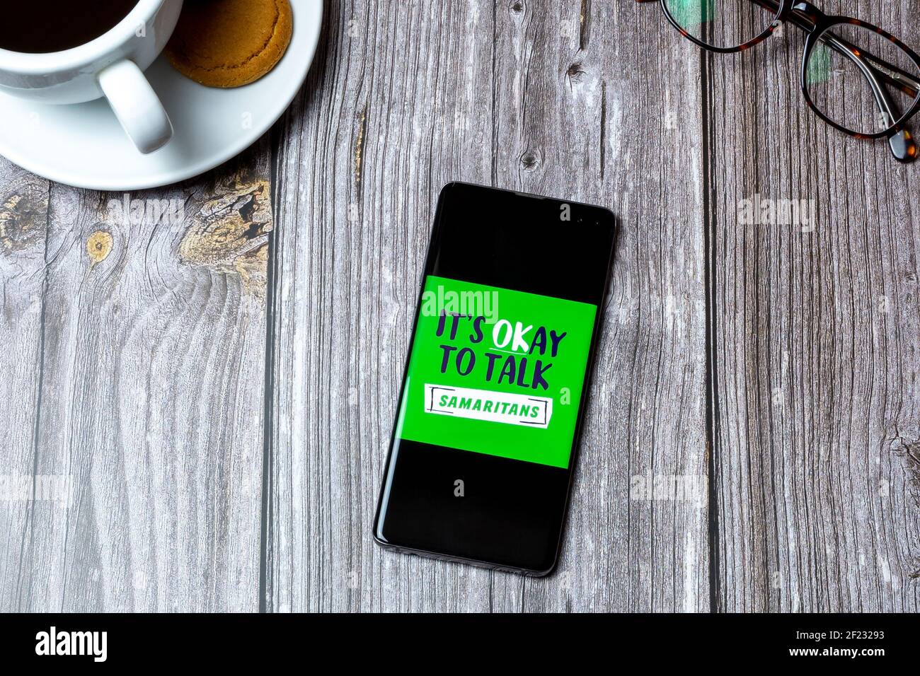 03-10-2021 Portsmouth, Hampshire, UK MOBILTELEFON oder Mobiltelefon auf einem Holztisch mit dem Samaritans-Logo auf dem Bildschirm Stockfoto