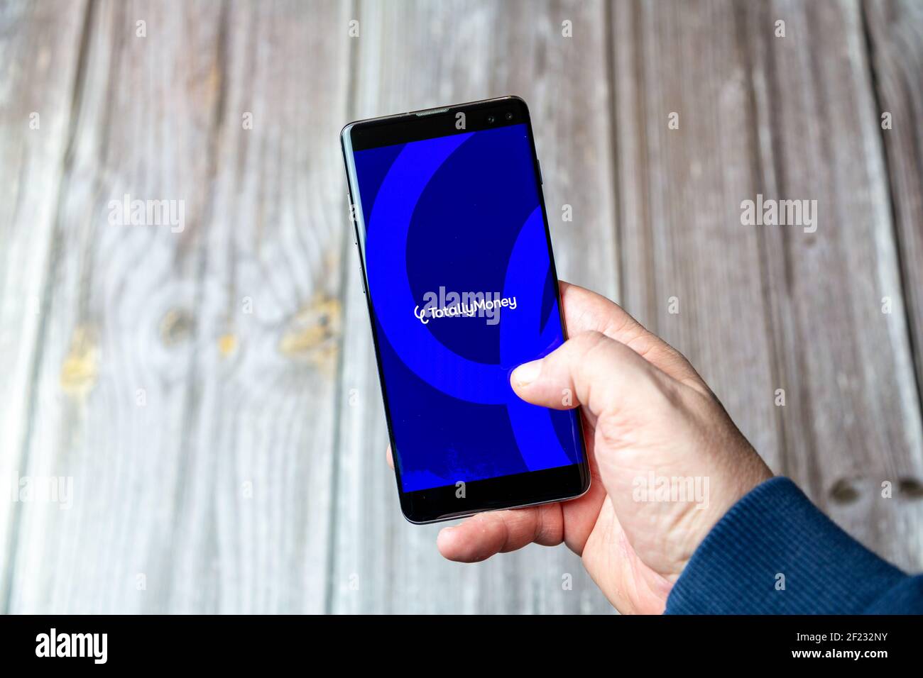 Ein Mobiltelefon oder Mobiltelefon, das in einem gehalten wird Hand mit der Totally Money App auf dem Bildschirm geöffnet Stockfoto