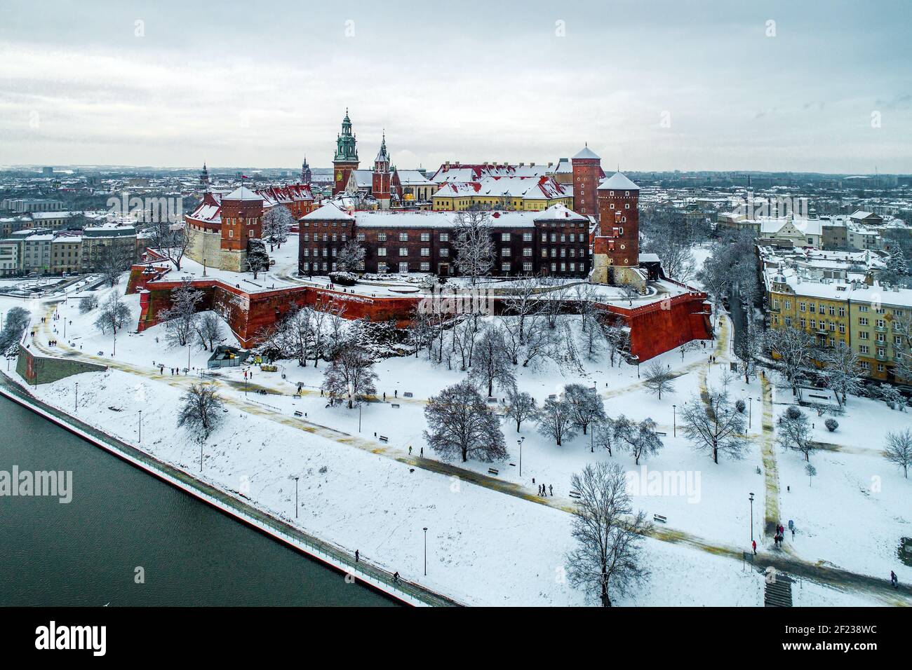 Historisches königliches Wawel Schloss und Kathedrale in Krakau, Polen, mit Weichsel, Spaziergänger, Schnee und Promenade im Winter Stockfoto