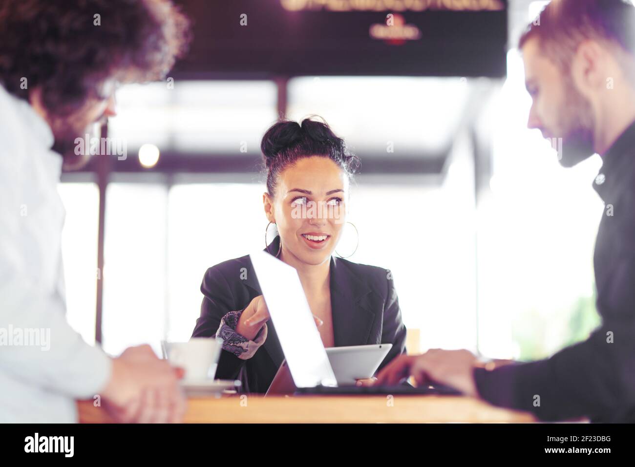 Glückliche Geschäftsfrau in einem Café mit Kollegen. Kreative Meetings außerhalb des Büros. Stockfoto