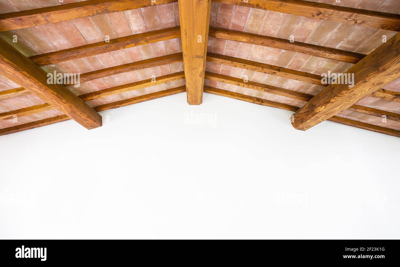 Toskanische traditionelle Eichenholzbalkendecke, rote Ziegelsteine Muster und weiße Wand als Copyspace. Klassische italienische ländliche Inneneinrichtung. Stockfoto