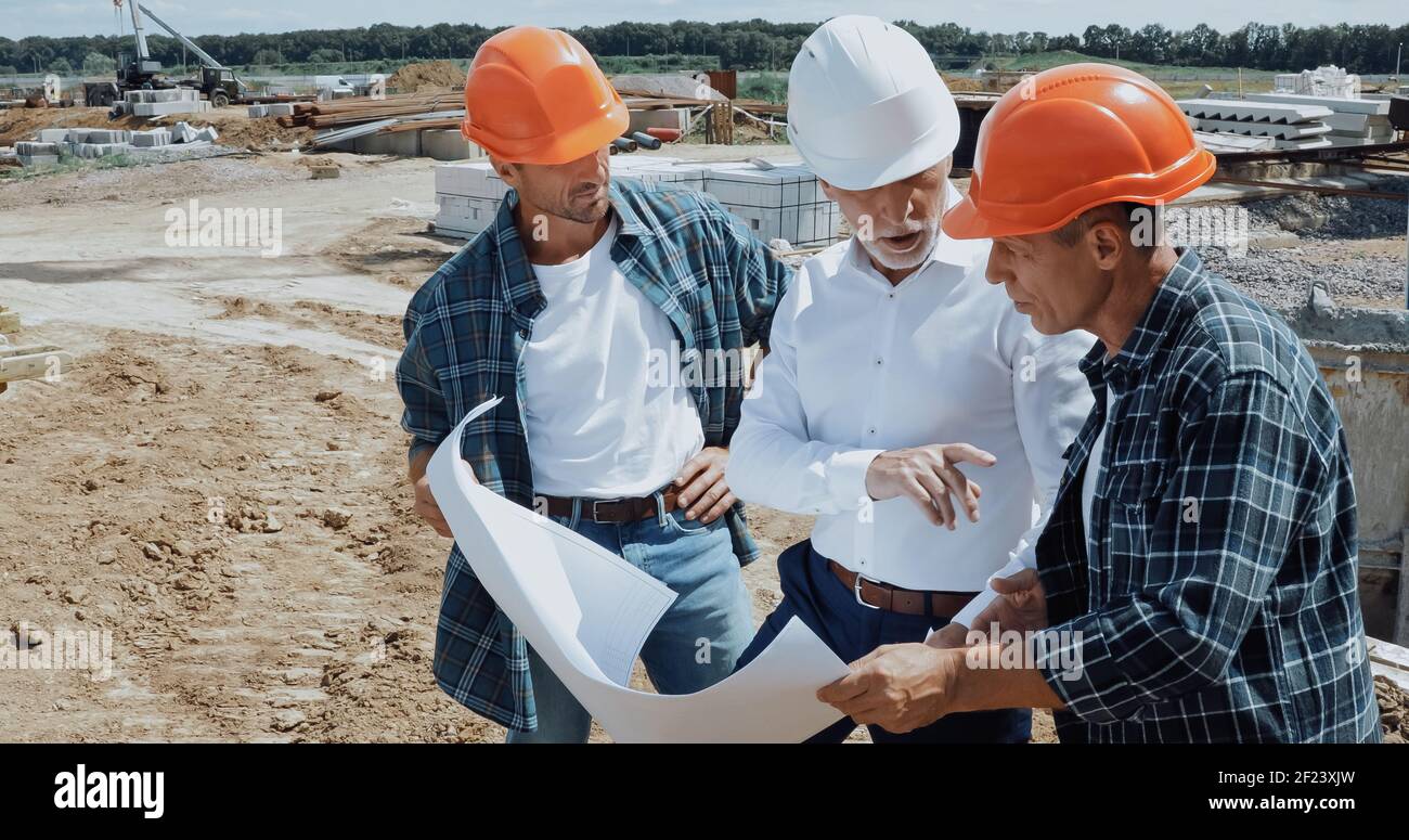 Ingenieur und Bauherren diskutieren Bauplan auf der Baustelle Stockfoto