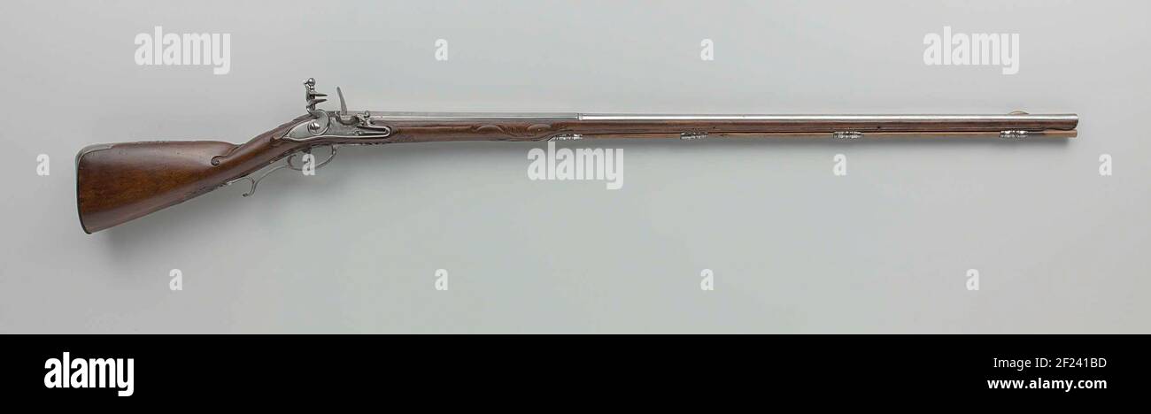 Vuursteenjachtgeweer.der Schlitz ist leicht graviert mit Lob, eine Grenze und eine Signatur. Die Schlaufe ist mit einer vergoldeten, Selektor-Schaukörnung und einer Signatur ausgestattet. Die Flasche hat eine einfache Schnitzerei mit Akanthus-Blättern und Hochrelief. Der Teig aus poliertem Eisen besteht unter anderem aus dem Flexurauslöseblech, einer aczo-förmigen Schraubplatte, einer unbearbeiteten Daumenplatte mit einem krautigen Blatt oben und unten, einem Kolben mit der Nummer 6 graviert, der Spitze als Blatt geprägt und dem Holzladestift. Stockfoto