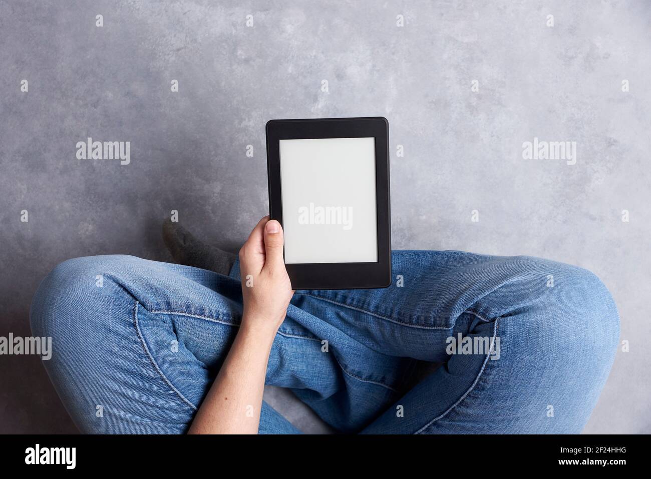 Subjektive Ansicht einer jungen Person, die einen elektronischen Leser mit leerem Bildschirm hält. Konzepte: Technologie und Lesen. Bild mit Kopierbereich Stockfoto