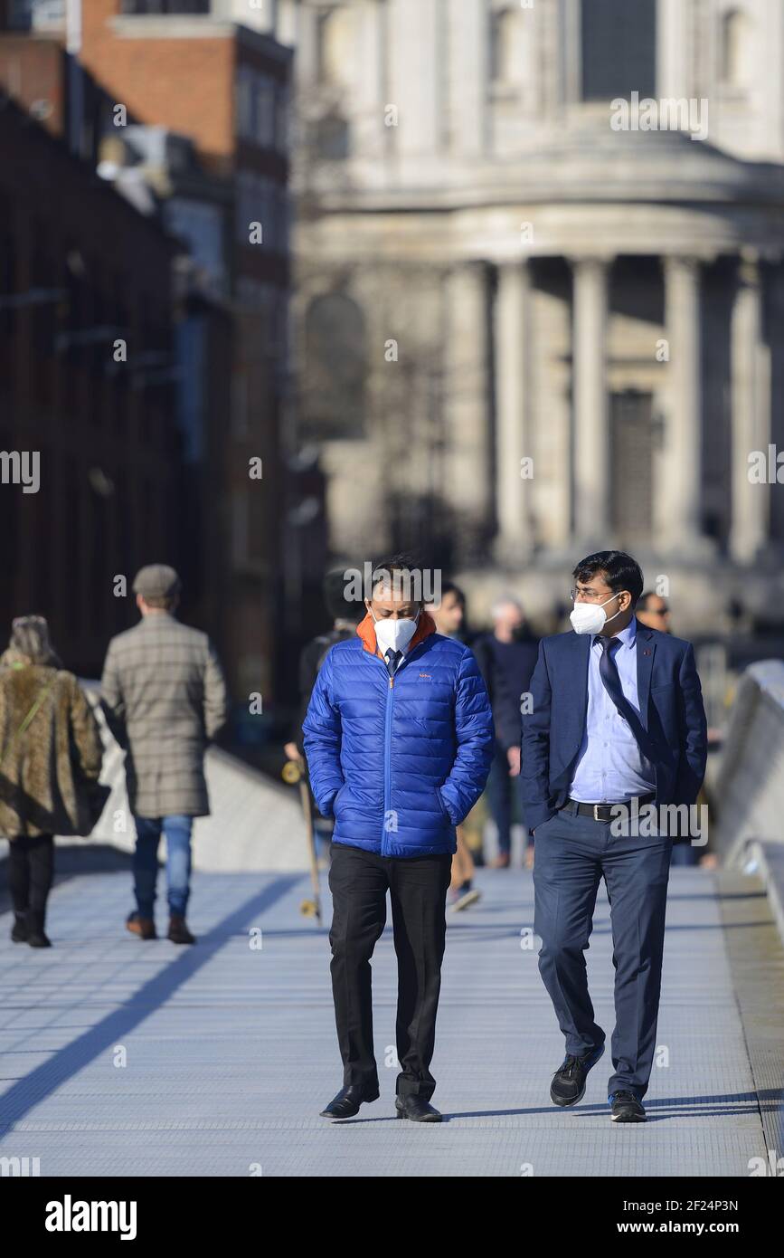 London, England, Großbritannien. Menschen, die während der COVID-Pandemie die Millennium Bridge mit Gesichtsmasken überqueren, März 2021 Stockfoto