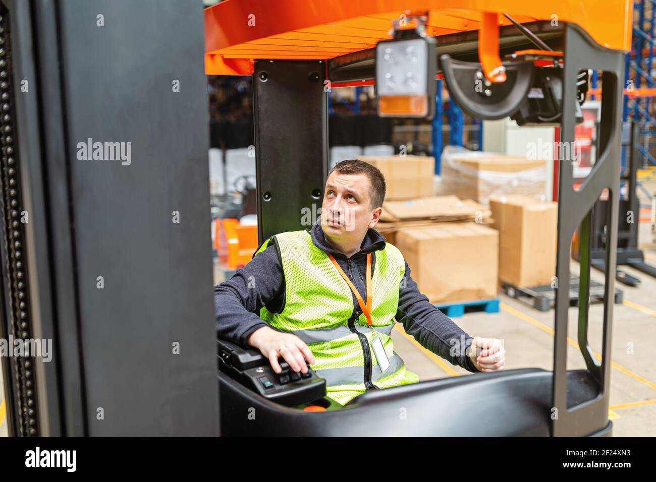 Lagermitarbeiter in Uniform arbeiten auf einem Sattelzug in einem modernen automatischen Lager. Lagerhaltung, Maschinenkonzept. Logistik auf Lager. Stockfoto