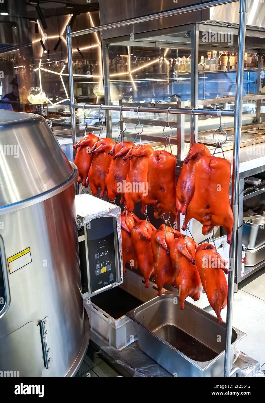 Eingelegte Entenkadaver, die an Haken hängen, für das Braten im Ofen vorbereitet. Pekingente. Chinesische Küche. Stockfoto