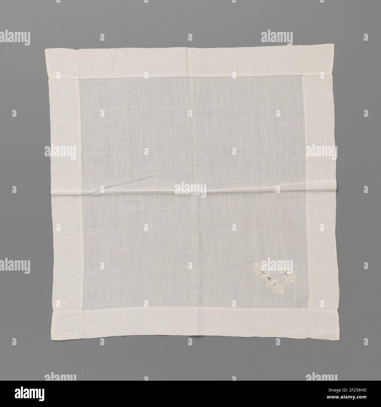 Zakdoek van batist met geborduurde Letter L in witwerk.natürliches batist Taschentuch mit weißer Arbeit. Quadratisches Modell mit breiten Abschlüssen. EEM durchbrochener Buchstabe L ist in einer Ecke gestickt, verziert mit Blättern, drei Rosettenblüten dreimal und einer Rosettenblüte einmal. Eine sehr schmale Schnittkante verläuft entlang der Säume. Stockfoto
