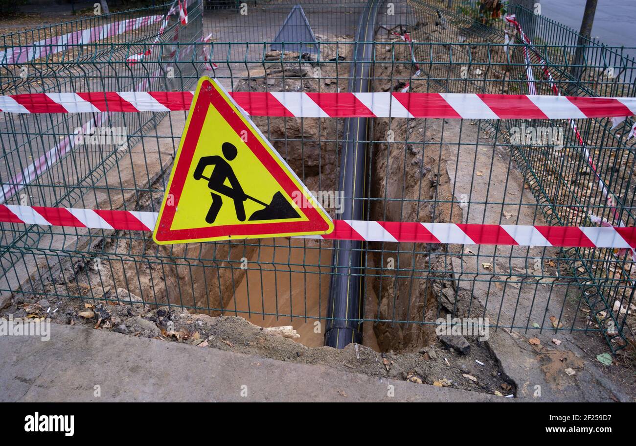 Reparatur der unterirdischen Pipeline. Verlegung eines Kunststoffrohrs durch Festziehen in den Untergrund Stockfoto