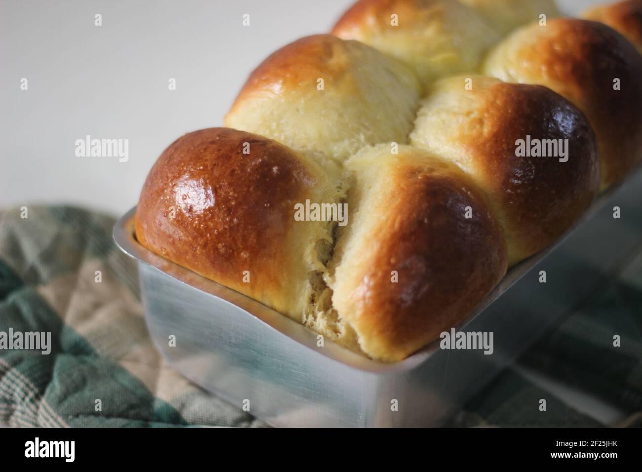 Frisch gebackener Brioche Brotlaib in der Loftdose. Aufnahme auf weißem Hintergrund. Stockfoto