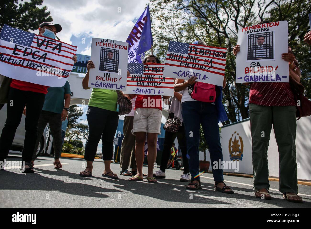 Aktivisten halten Plakate gegen die fortgesetzte Präsenz von US-Stützpunkten im Land vor einem Militärhauptquartier in Manila auf den Philippinen. Stockfoto