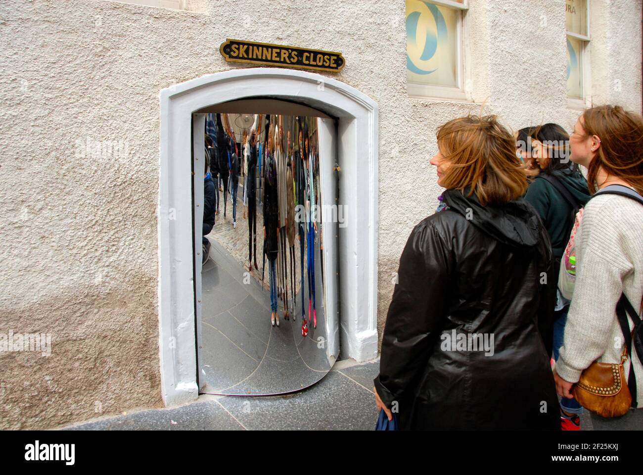 Gruppe junger Frauen, die sich in einem großen verzerrenden Spiegel betrachten, Edinburgh, Schottland Stockfoto