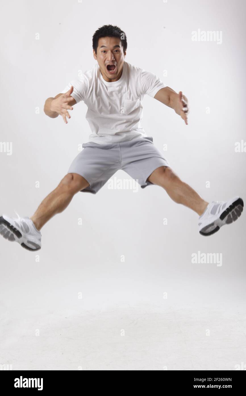Ein junger Mann, der in legerer Kleidung springt Stockfoto