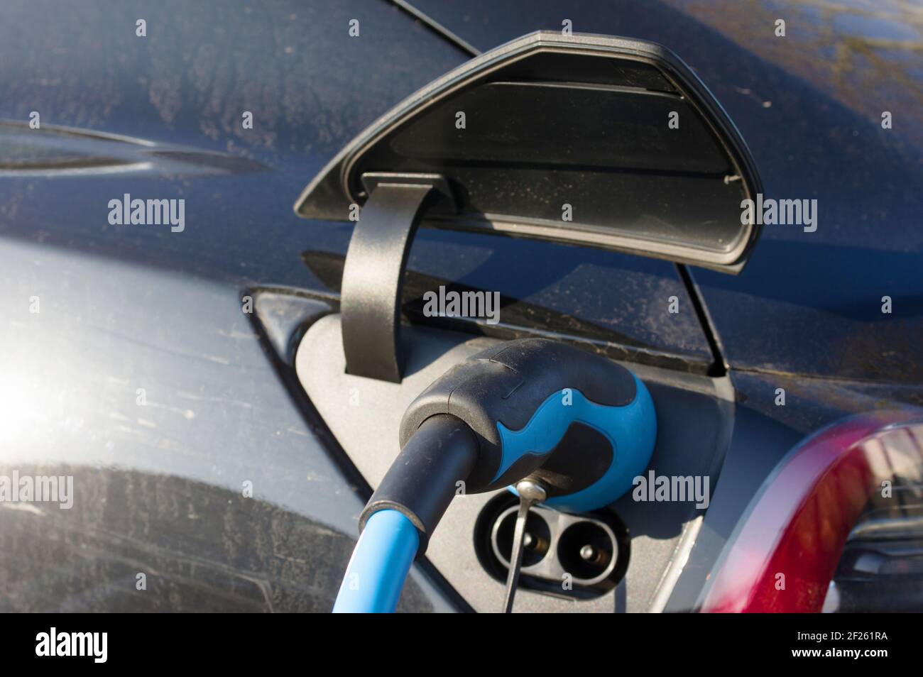 Nahaufnahme eines blauen und schwarzen Netzsteckers eines Elektroauto mit angeschlossenem Ladekabel Stockfoto