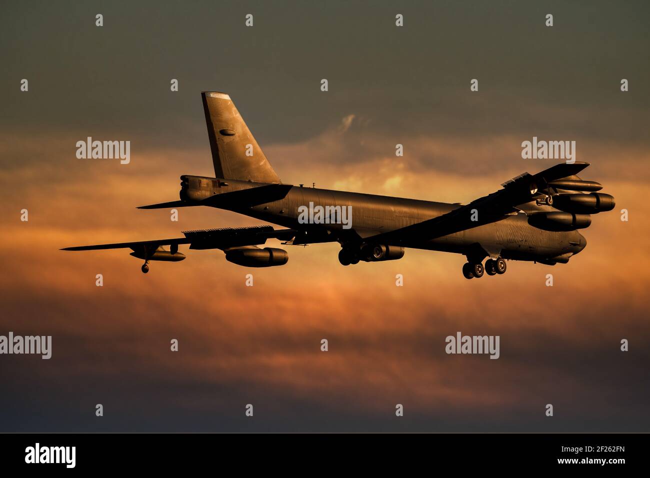 B52 Bomberlandung bei Sonnenuntergang. Die Boeing B-52 hat einen Atombomber gegen einen orangefarbenen Himmel angetrieben Stockfoto