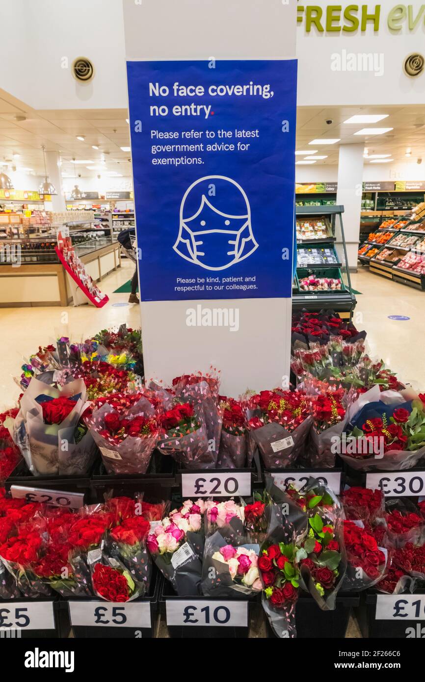 England, London, Supermarkt Valentinstag-Anzeige von Rosen mit Gesichtsbedeckung Awareness Sign Stockfoto