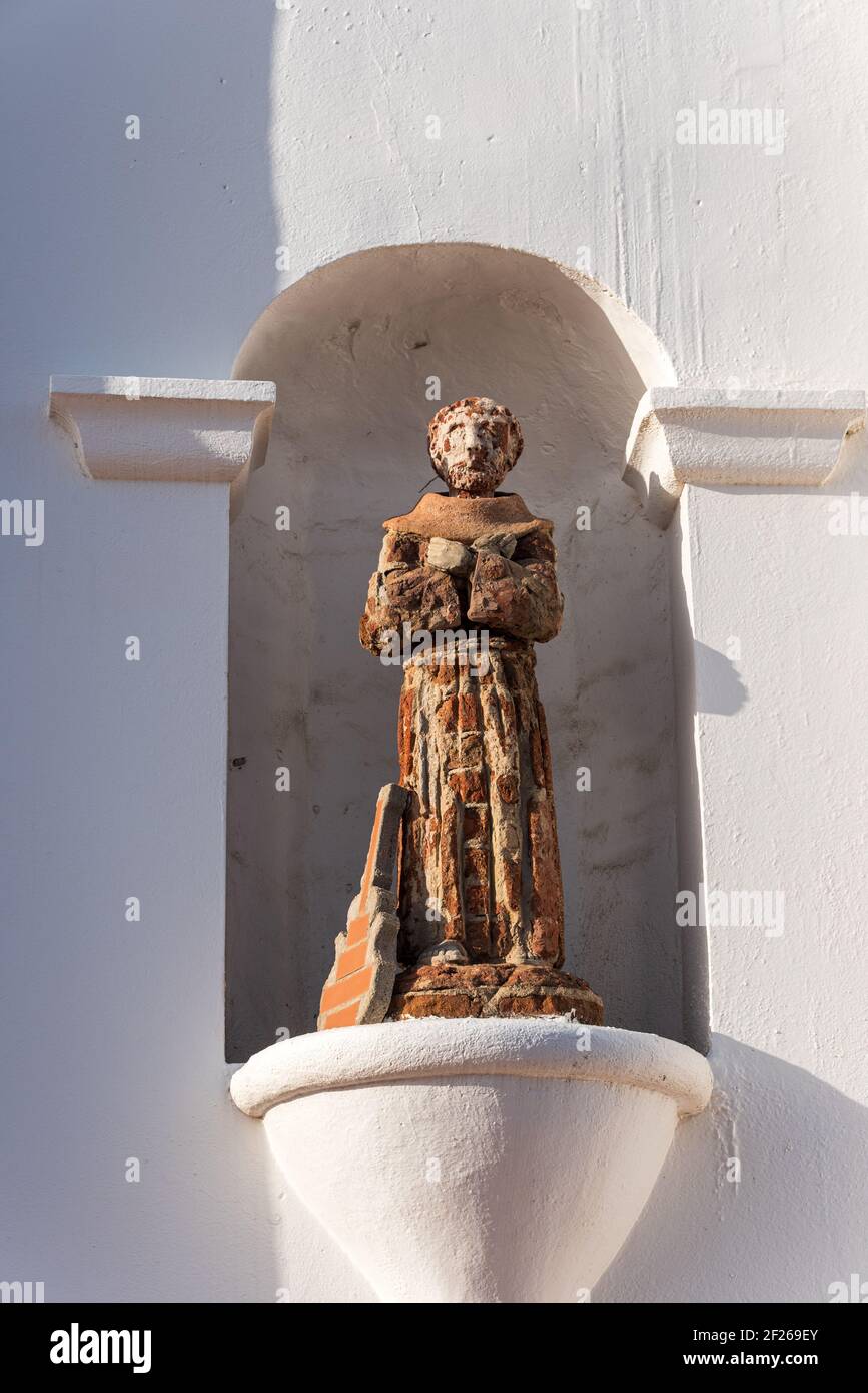 Statue in Nische in weißer Missionsmauer. Stockfoto