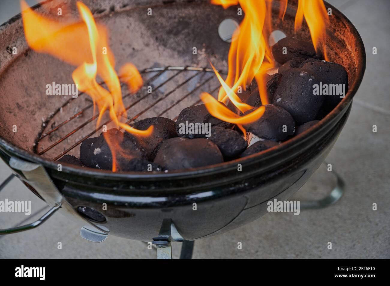 Runder Grill mit brennender Holzkohle Stockfoto