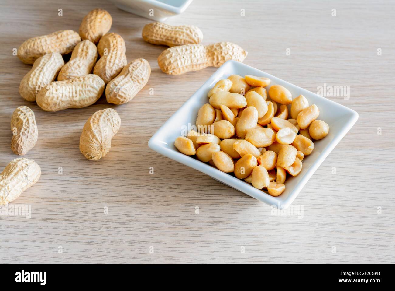 Ganze Erdnüsse mit Schale und geschälten Erdnüssen Stockfoto
