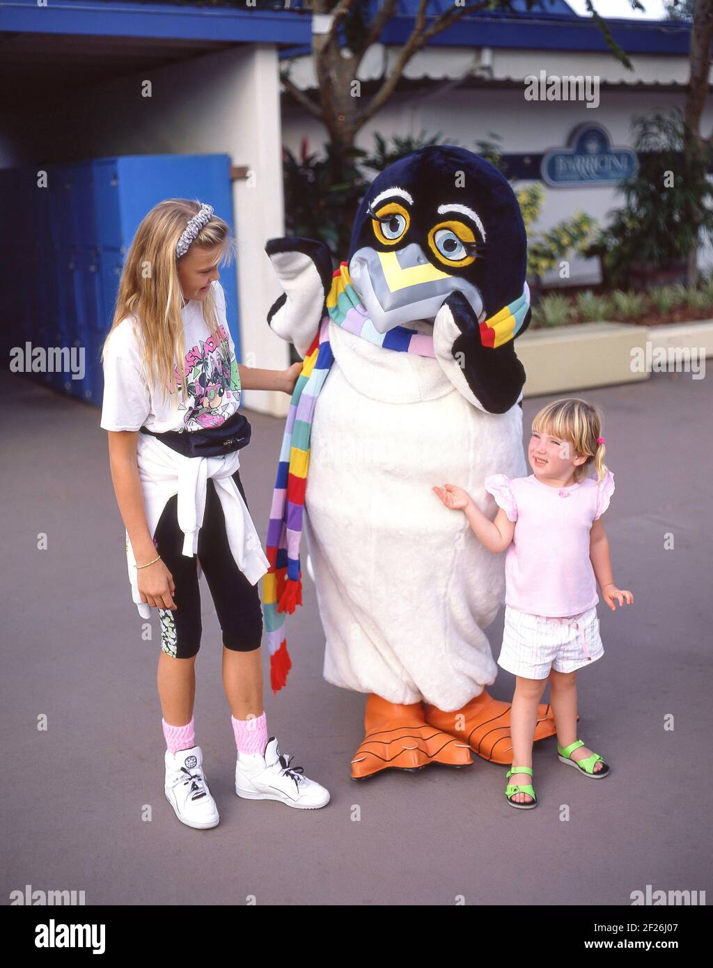 Junge Mädchen mit Pinguin-Charakter im Warner Bros Movie World Theme Park, Oxenford, City of Gold Coast, Queensland, Australien Stockfoto