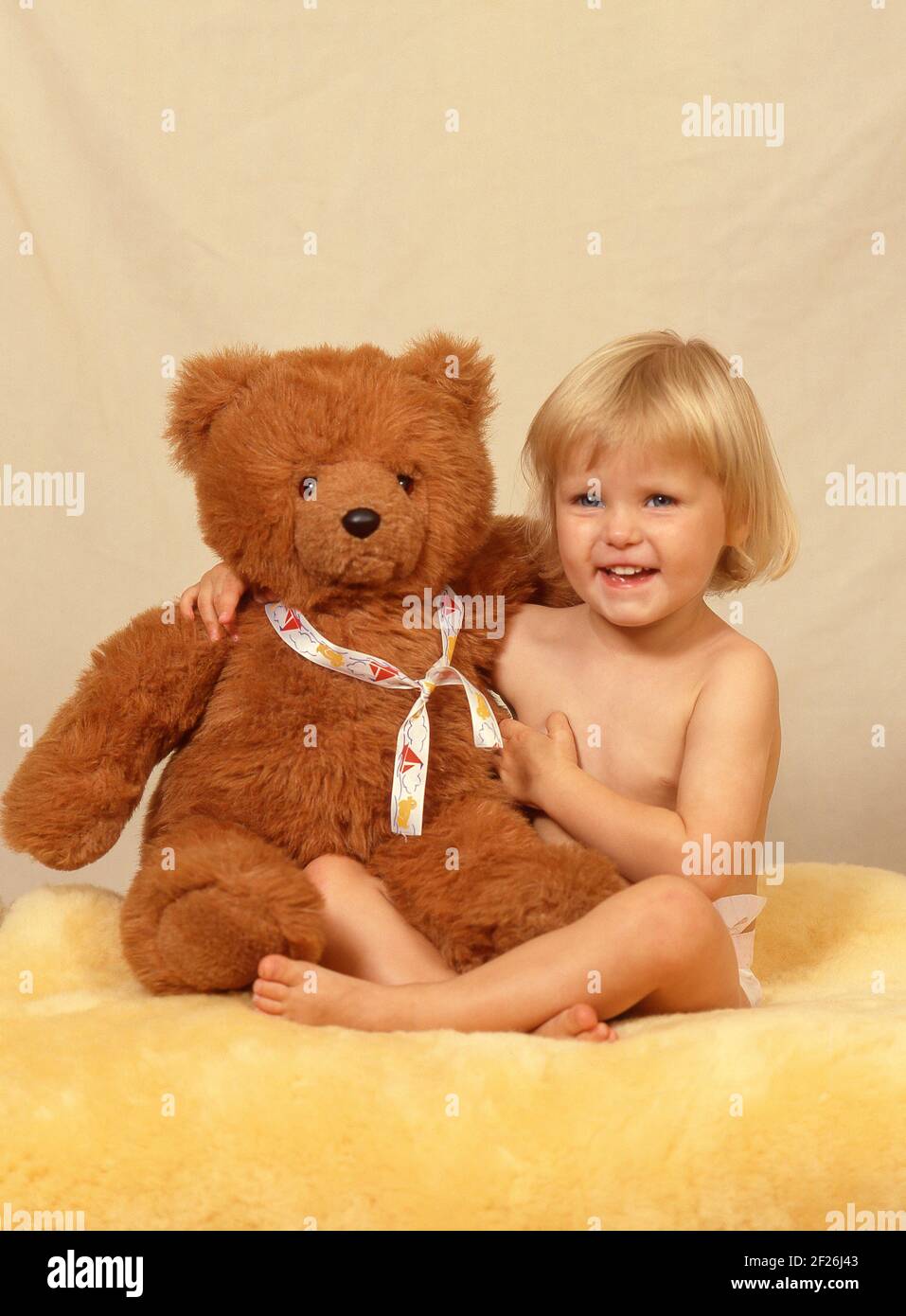 Kleinkind Mädchen hält Teddybär in Studio-Setting, Greater London, England, Vereinigtes Königreich Stockfoto