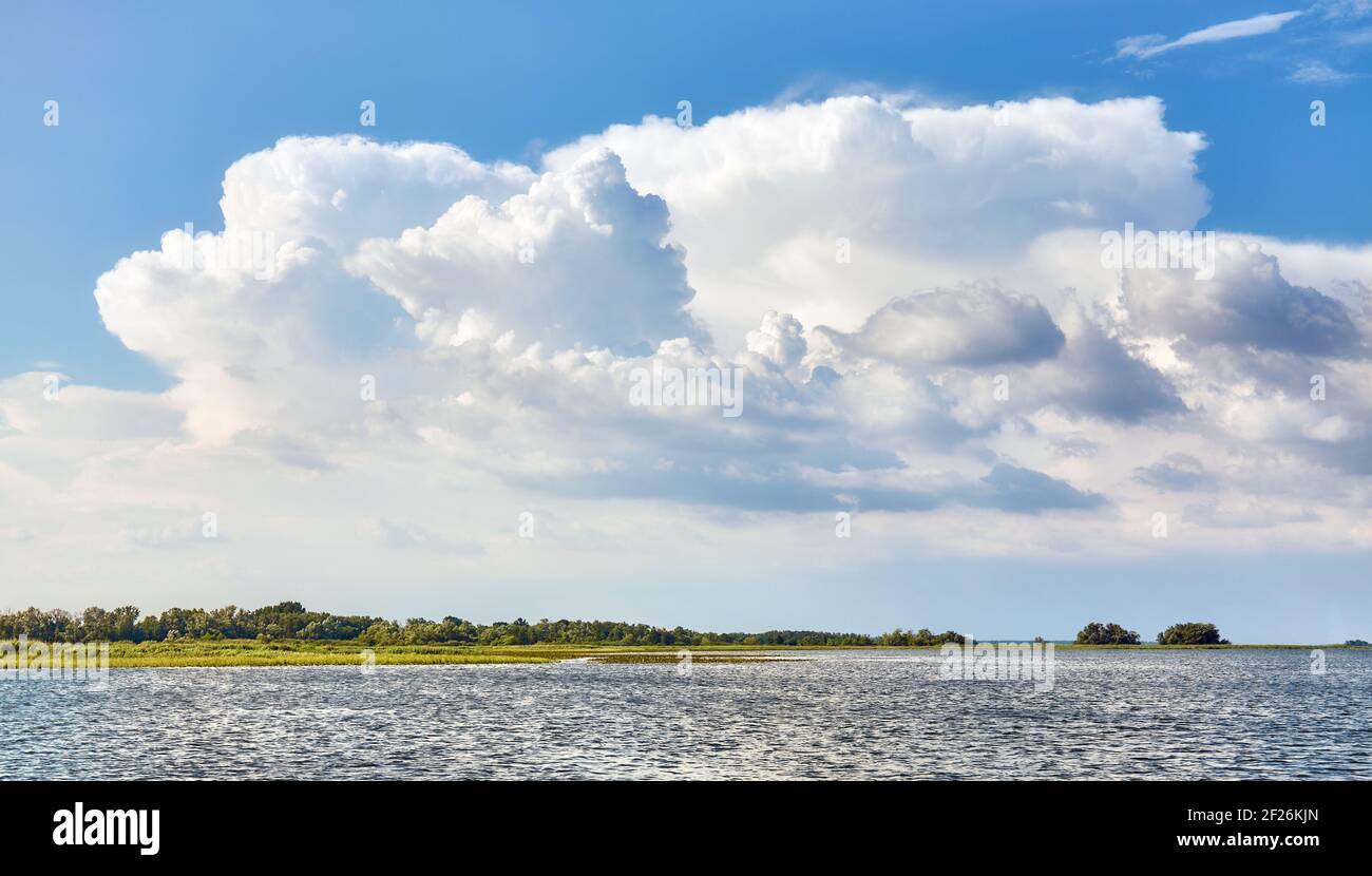 Landschaftlich reizvolle Wolkenlandschaft über Land und Wasser an einem sonnigen Tag. Stockfoto