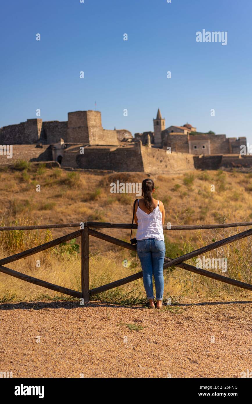 Kaukasische Frau beim Blick auf Juromenha Burg an einem Sommertag in Alentejo, Portugal Stockfoto