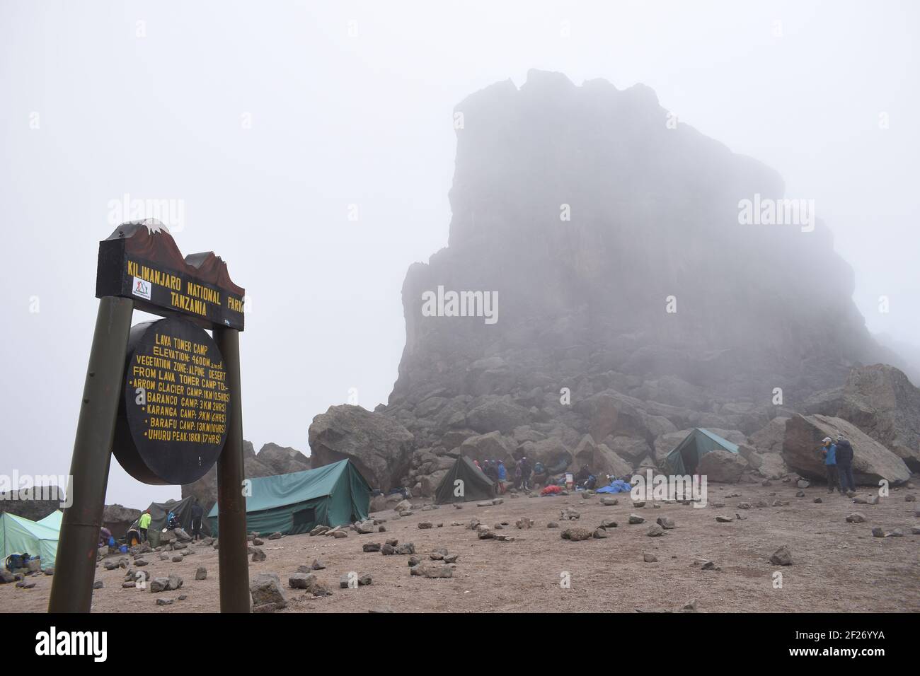 Blick auf den Lava Tower hinter dem ikonischen Schild am Lava Tower Camp in der alpinen Wüstenzone an den Hängen des Kilimandscharo 4600m über dem Meeresspiegel. Stockfoto