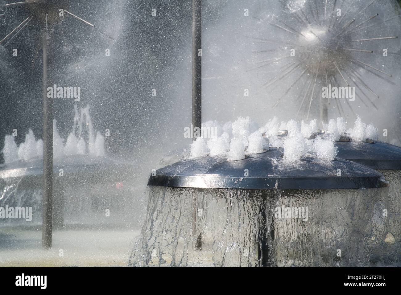 Wasser Spiele in einem Brunnen. Wasserauslauf-Brunnen mit Nebel, aus Edelstahl, pilzförmig, Wasserstrahl, sprudelnd. Wasserspiele Stockfoto