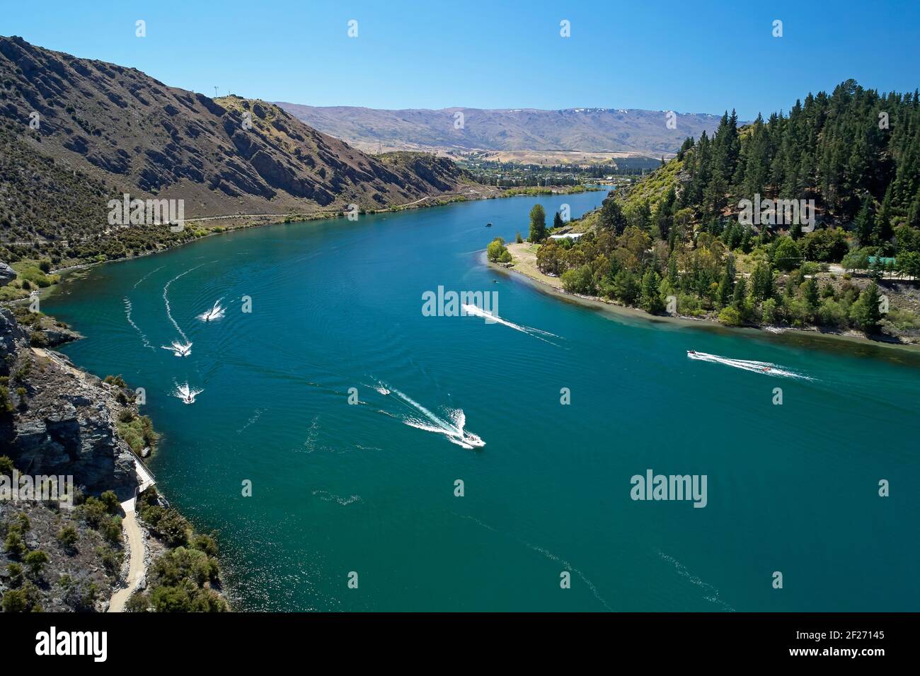 Lake Dunstan Radweg (links unten) und Boote auf Lake Dunstan, bei Cromwell, Central Otago, South Island, Neuseeland Stockfoto
