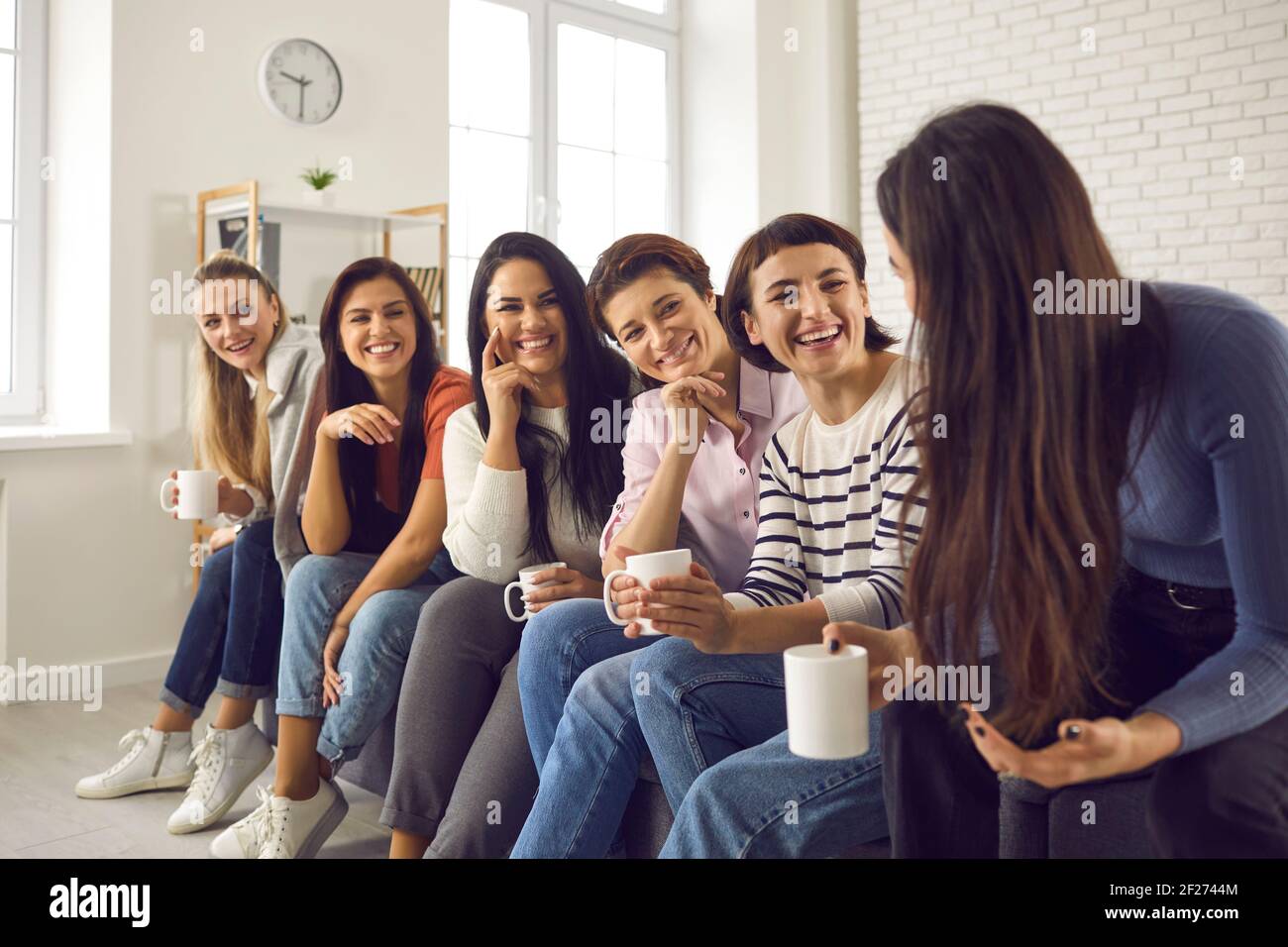 Gruppe von glücklichen jungen Frauen, die Kaffee genießen und zuhören Die Geschichten der anderen Stockfoto