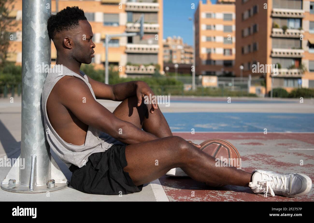 Müde schwarzen Basketballspieler auf dem Platz Stockfoto