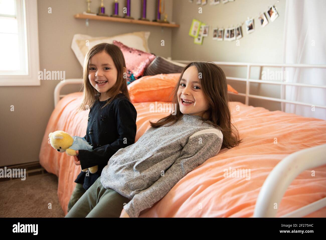 Zwei kleine Mädchen, die in ihrem Schlafzimmer lachen. Stockfoto