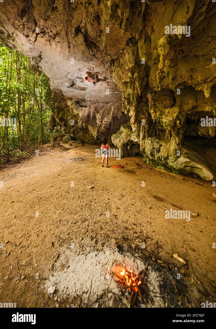 Junger Mann klettert über die Felswand im Wald bei Railay Strand Stockfoto