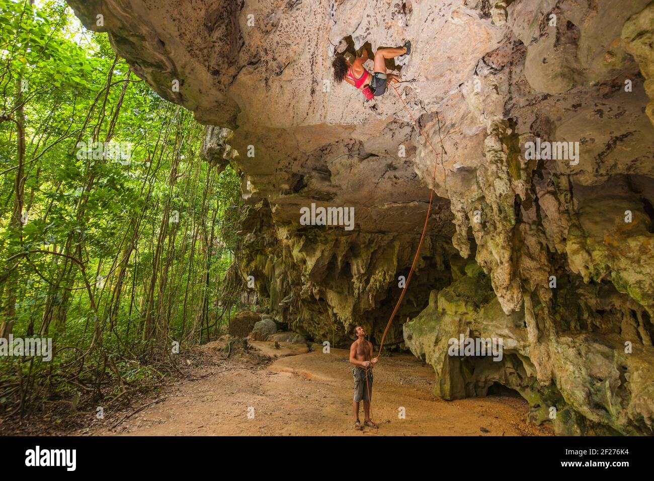Frau klettert über die Felswand im Wald bei Railay Strand Stockfoto