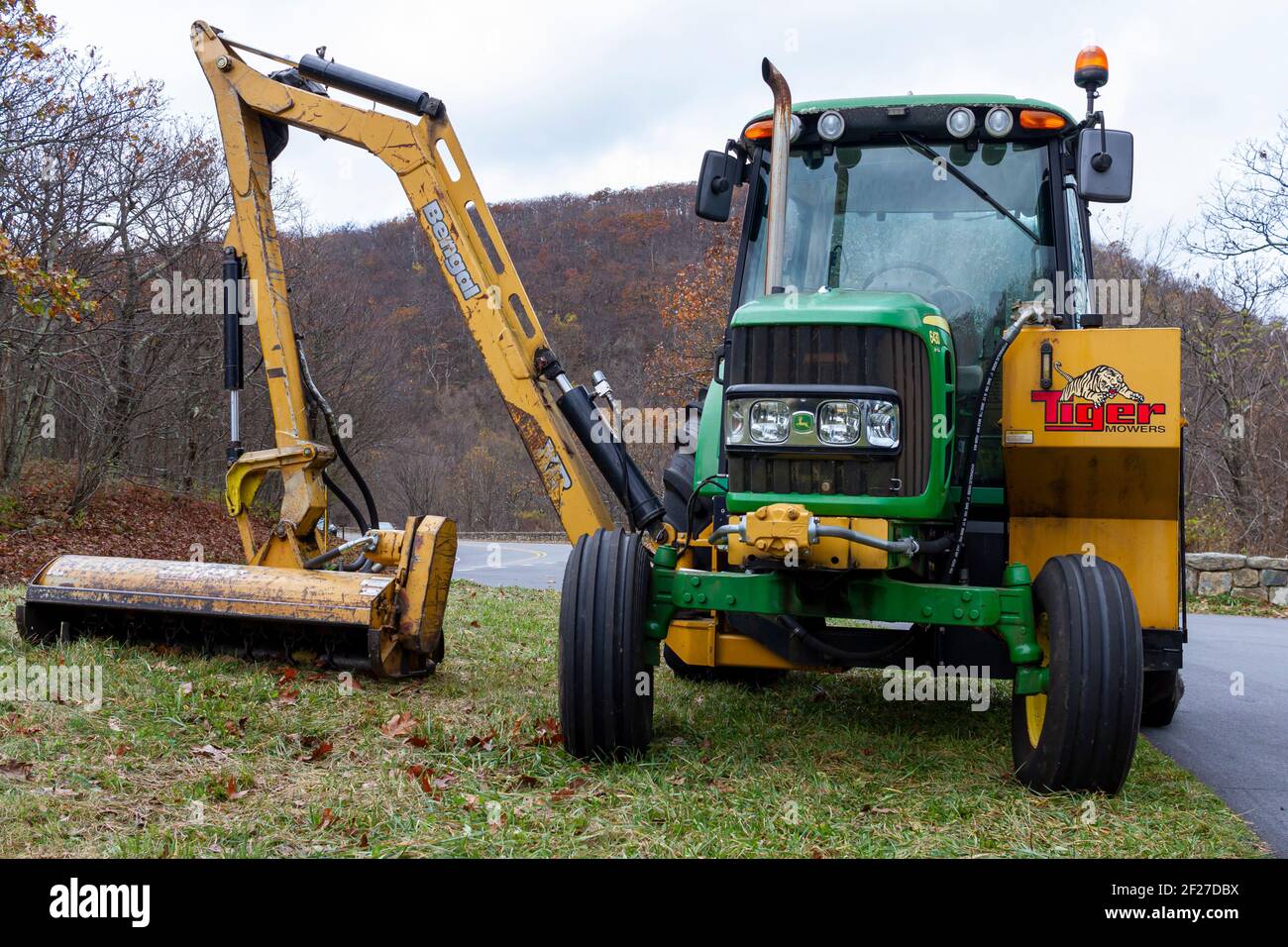 Shenandoah, VA, USA 10-31-2020: Ein grüner John Deere Modell 6430 Traktor mit SEITLICHER hydraulischer Armbefestigung (Bengal XR) von Tiger Mähers. Dieser Anhang Stockfoto